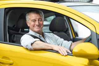 Senior man driving a yellow car