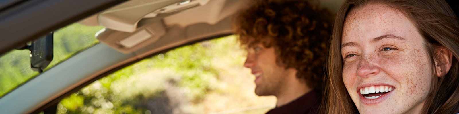 lady and man in a car smiling