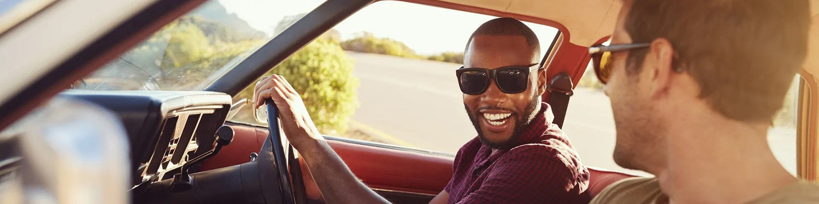 male driving a car smiling at passenger