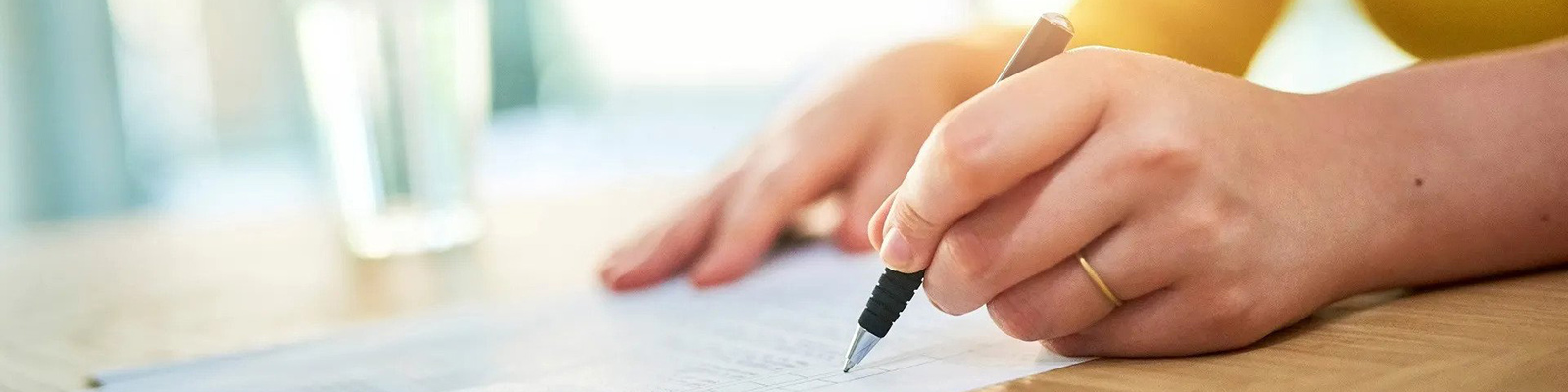 person holding pen and writing