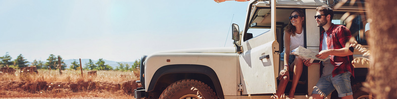 woman and man standing by stationary car in desert