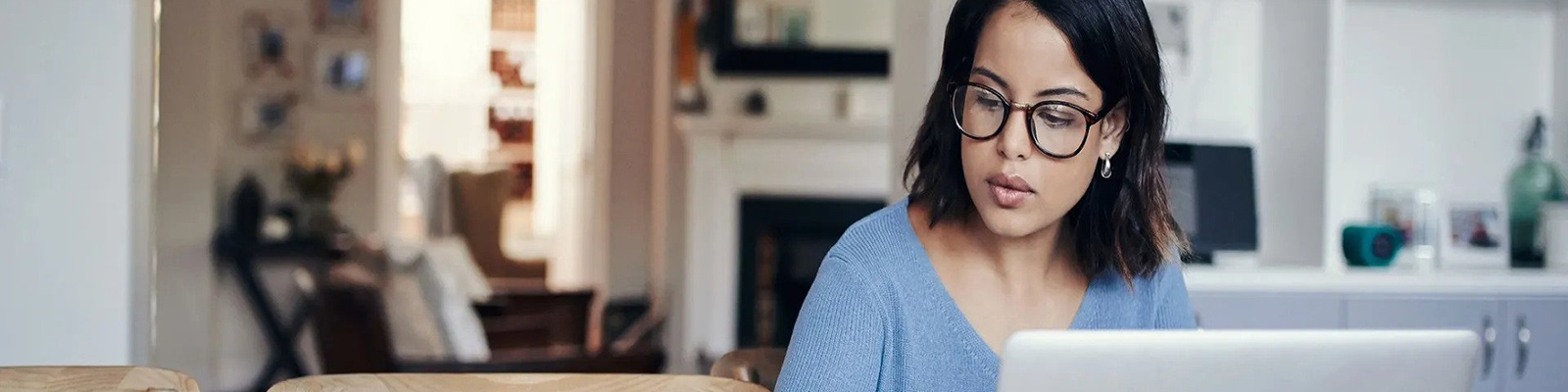 woman calculating budget with laptop in the kitchen