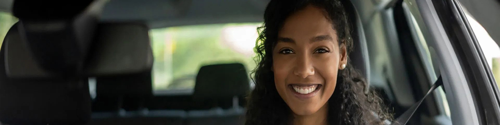 young girl driving car and smiling