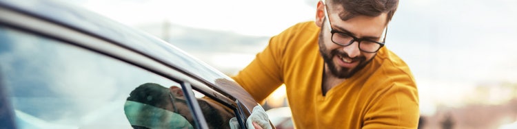 Man in yellow cleaning his car