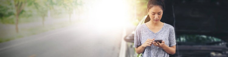 Woman with mobile phone looking stressed after car accident