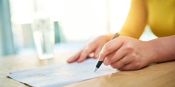 Woman writing with pen on piece of paper