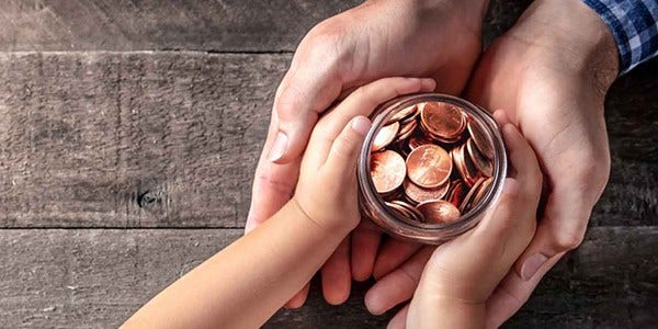 Father giving jar of coins to child