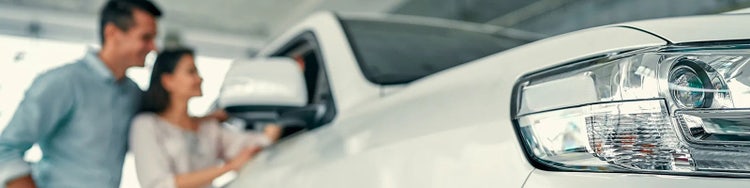 Man and woman looking at white car
