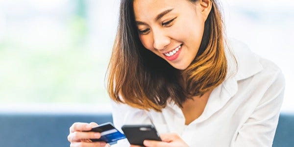 Woman on phone using credit card