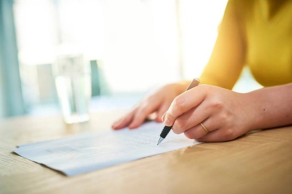 Woman signing a paper document