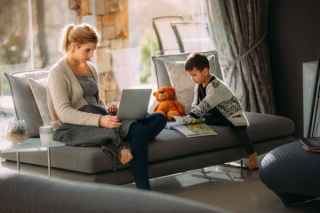 Lady working on couch with child